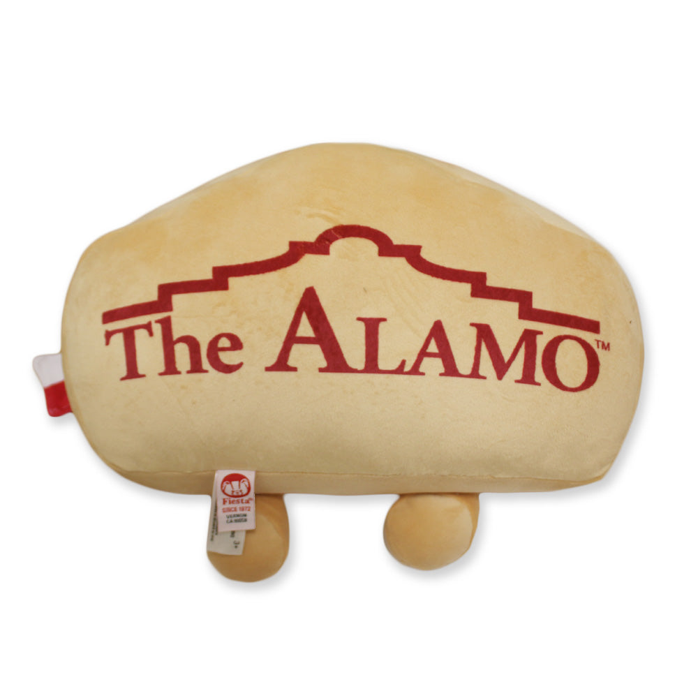 The Alamo Building Plush is a soft toy designed like the iconic Texas landmark, with "The ALAMO" in red on the front, two small legs, and tags below—paying tribute to the historic 1836 battle.