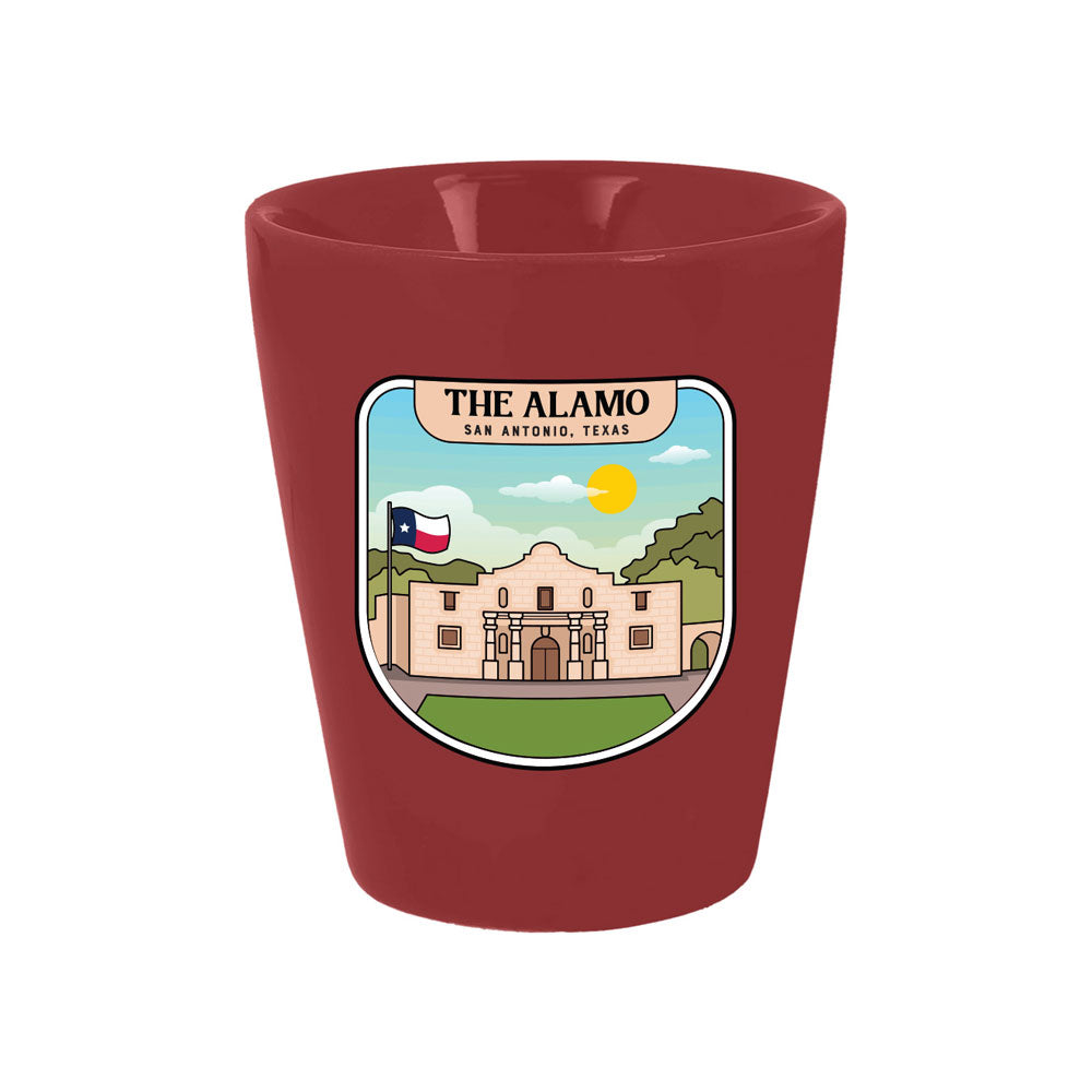 This vibrant red collectible is The Alamo Building Foil Shot Glass, showcasing an illustration of The Alamo in San Antonio, Texas. The design features the Texas flag, a green landscape, and a yellow sun in the background, with the words “The Alamo San Antonio, Texas” displayed above the image. This historic souvenir makes an ideal addition to any Alamo shot glass collection.