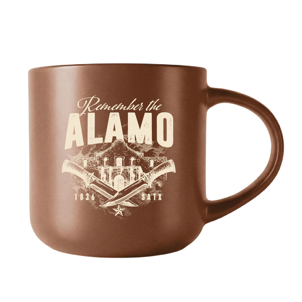 Brown ceramic Remember the Alamo Mug featuring a graphic of the mission, two crossed knives, and the text 1836 SATX.