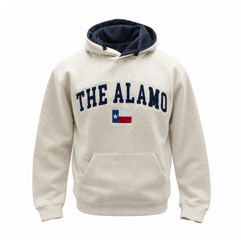 The Alamo Applique Hooded Sweatshirt is a beige unisex hoodie featuring “THE ALAMO” in navy applique lettering above a small Texas flag, with a front pocket and a dark blue inner hood lining—combining comfort with classic style.